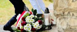 Uczeń składa kwiaty i znicze pod pomnikiem żołnierzy