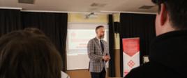 Dyrektor szkoły opowiada uczniom o zaletach nauki w II LO, w tle prezentacja