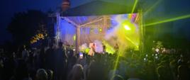 zdjęcie przedstawiające scenę wraz z widzami przed nią w nocnej scenerii