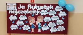 Gazetka stojąca na drewnianych nogach, przedstawiająca dziewczynkę i chłopca, w chmurkach napisane są cechy dziecka autystycznego, z prawej strony dwa nadmuchane niebieskie balony