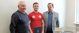 Na zdjęciu widać trenera judo Pana Józefa Jopka, zawodnika judo Adama Stodolskiego i Burmistrza Miasta i Gminy Kaczory Pana Brunona Wolskiego