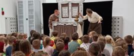 Dzieci oglądają sztukę teatralną z udziałem aktorów
