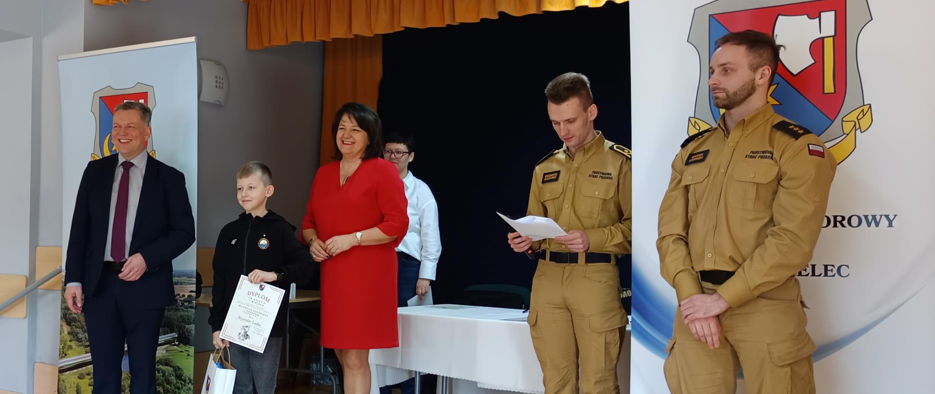 Od lewej: Wójt Gminy Mielec, uczeń ZS Chorzelów, Pani Wice Wójt Gminy Mielec oraz przedstawiciele Straży Pożarnej 