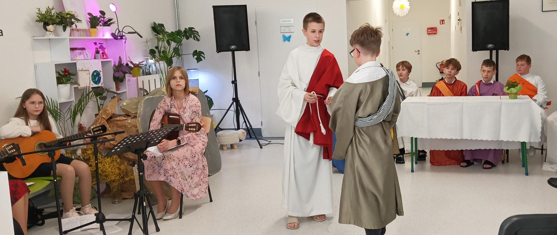 Uczniowie w strojach podczas przedstawienia.
