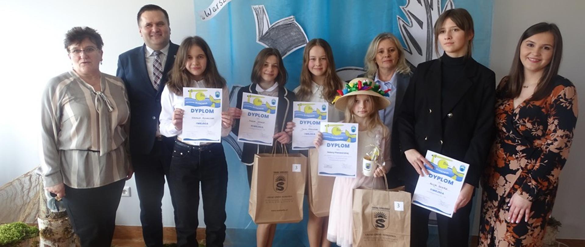 Zdjęcie przedstawia wójta Gminy Somianka, zwycięzców oraz organizatorów gminnych eliminacji konkursu recytatorskiego „Warszawska Syrenka” pozujących do zdjęcia. 