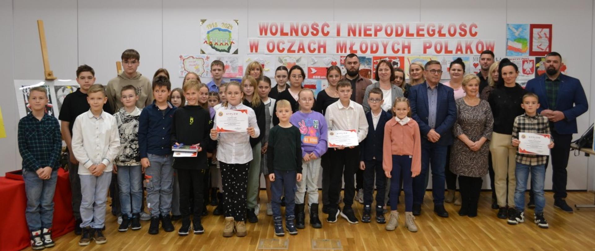 Na zdjęciu widać radnych Miasta i Gminy Kaczory oraz dzieci biorące udział w konkursie Wolność i Niepodległość oczami młodych Polaków