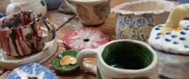 Na szarym tle zdjęcie wyrobów ceramicznych, u góry i dołu zdjęcia znajdują się napisy organizacyjne, zawarte w artykule
