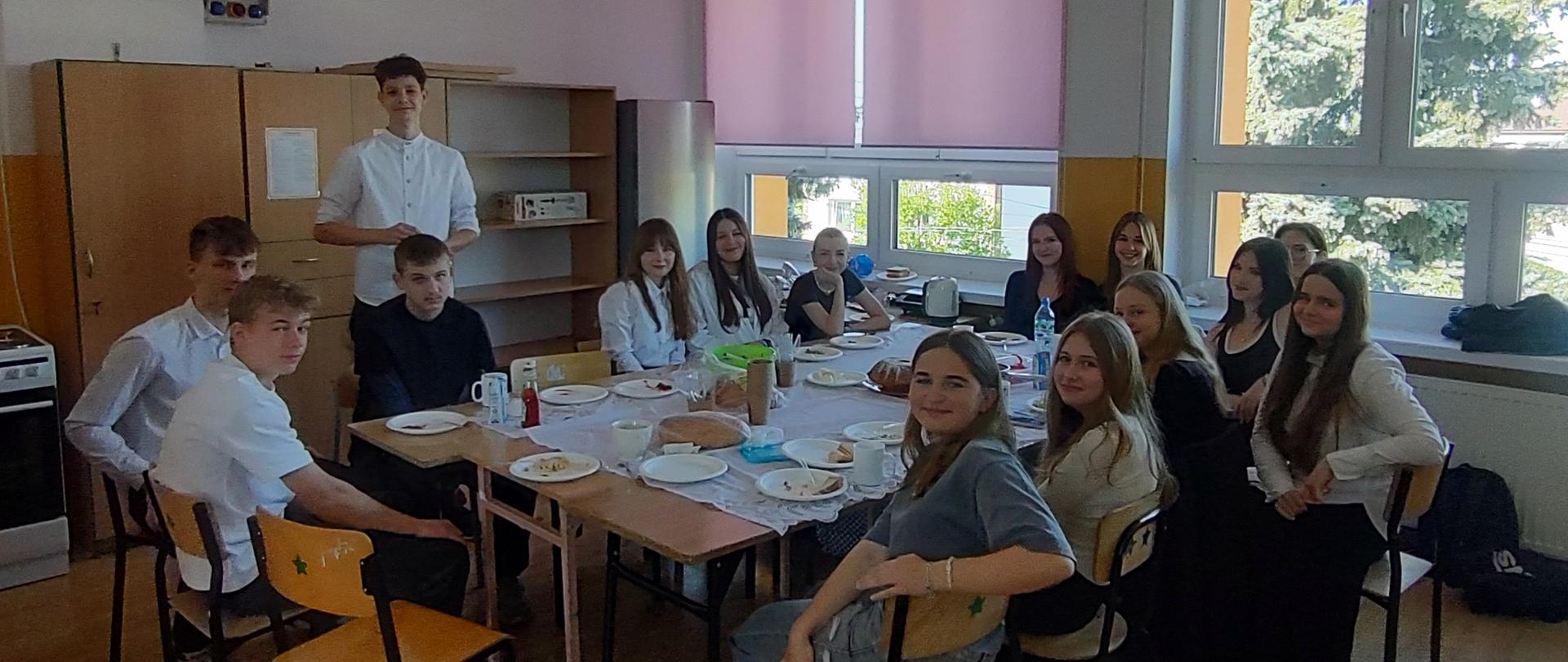 Przy stole siedzą uczniowie klasy VIII