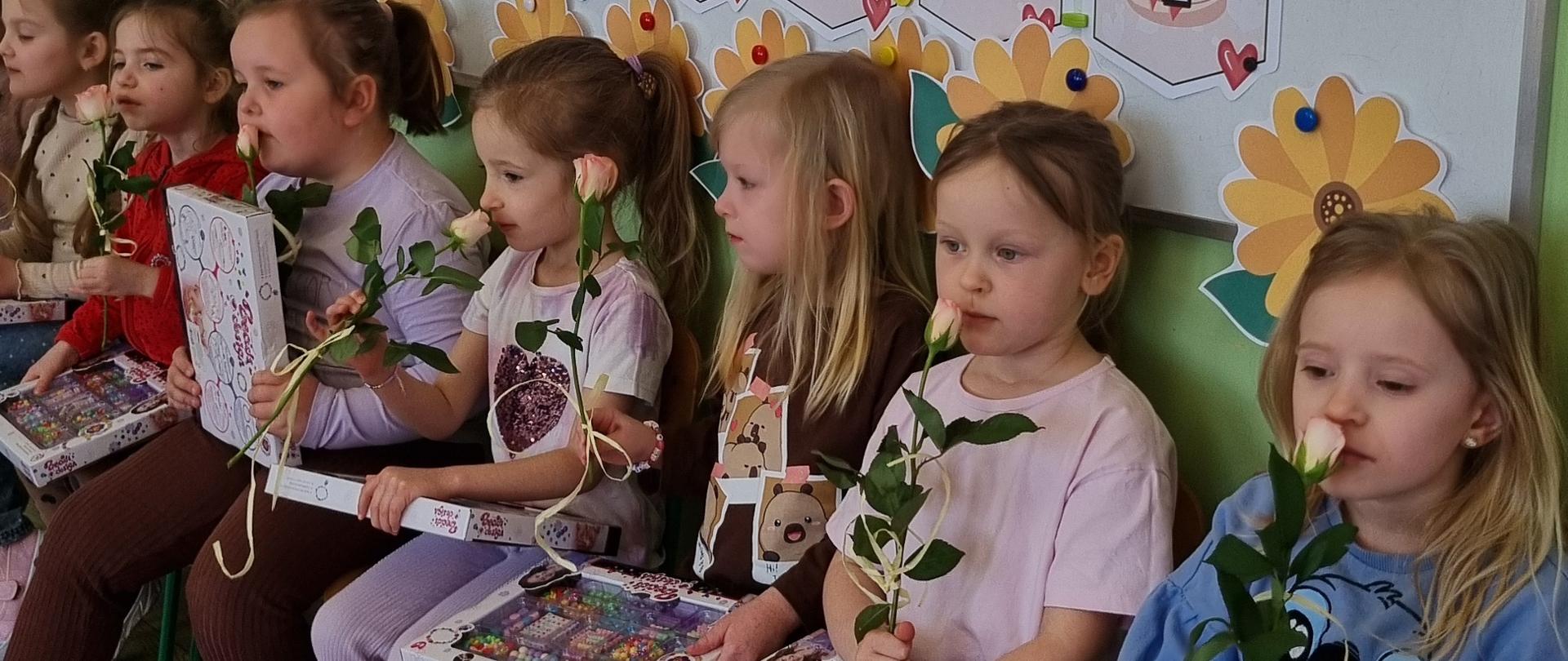 Grupa dzieci pozuje z upominkami z okazji Dnia Kobiet