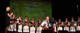 Zespół w strojach ludowych i akordeonistą na scenie