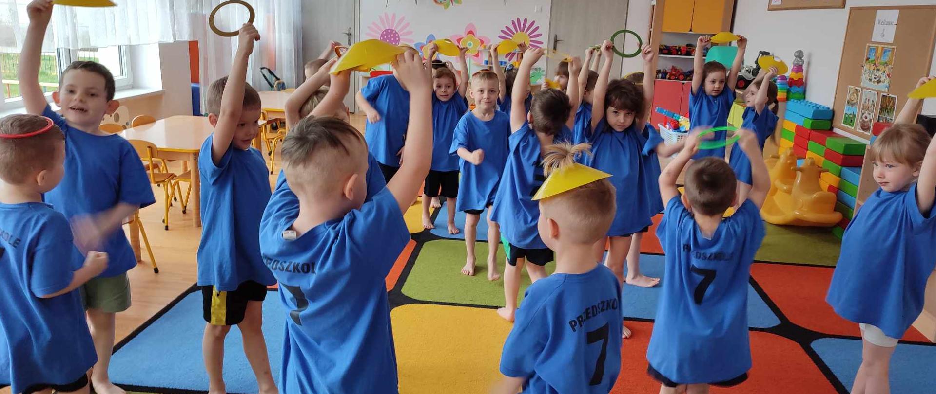 DZIECI WYKONUJĄ ĆWICZENIA GIMNASTYCZNE 