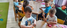 Zabawy artystyczne - wyklejanie serc przez grupę przedszkolną 