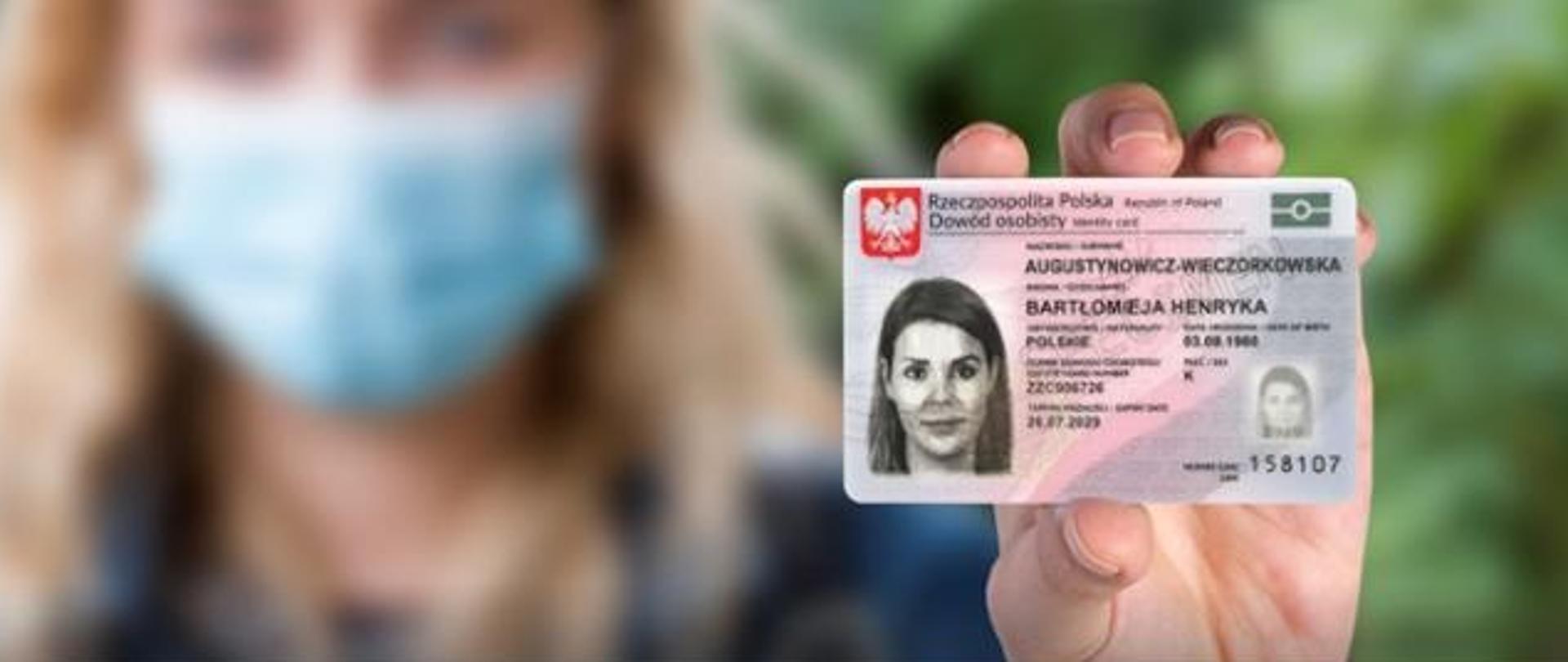 Kobieta w maseczce na twarzy trzyma w lewym ręku dowód osobisty