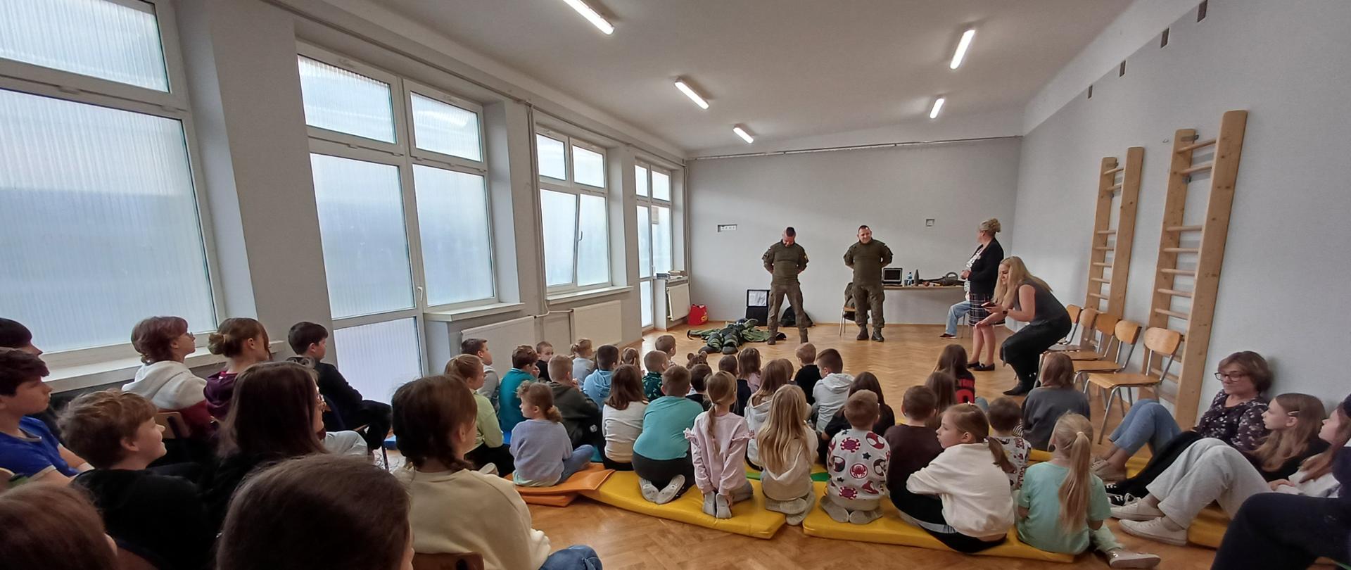 Zdjęcie przedstawia saperów, Panią Dyrektor witającą gości i uczniów szkoły.