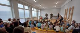 Zdjęcie przedstawia saperów, Panią Dyrektor witającą gości i uczniów szkoły.