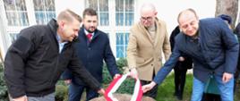 Od lewej: Wiceminister Klimatu i Środowiska, Wicestarosta Przasnyski, Dyrektor Liceum im. KEN oraz Burmistrz Przasnysza odsłaniają tablicę pamiątkową