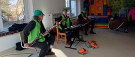 Artyści, którzy odwiedzili przedszkole. Siedzą przed dziećmi z instrumentami