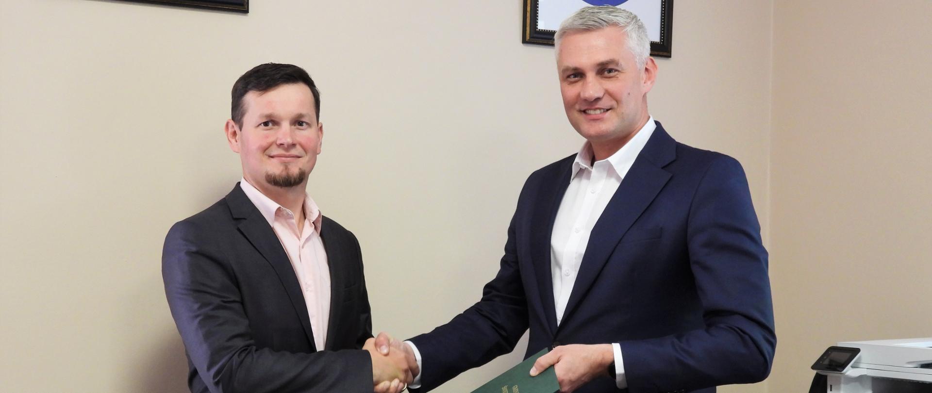 Adrian Blondzik i Grzegorz Zadęcki podają sobie dłonie w biurze wójta