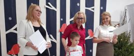 Dyrekcja Przedszkola wraz z przedstawicielką Nadleśnictwa Hajnówka wręczają nagrody dzieciom, pozując do wspólnego zdjęcia