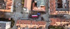Uczestnicy stoją dookoła flagi