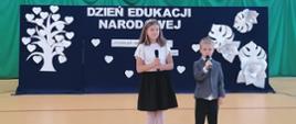 Chłopiec i dziewczynka z mikrofonami na akademii szkolnej
