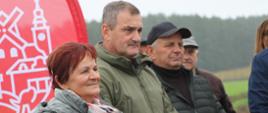 Grupa ludzi patrzy przed siebie. W tle widać nowo otwartą drogę.