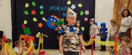 Dzieci ubrane w przygotowane przebrania z recyklingu, idą po "wybiegu" - kolorowym dywanie