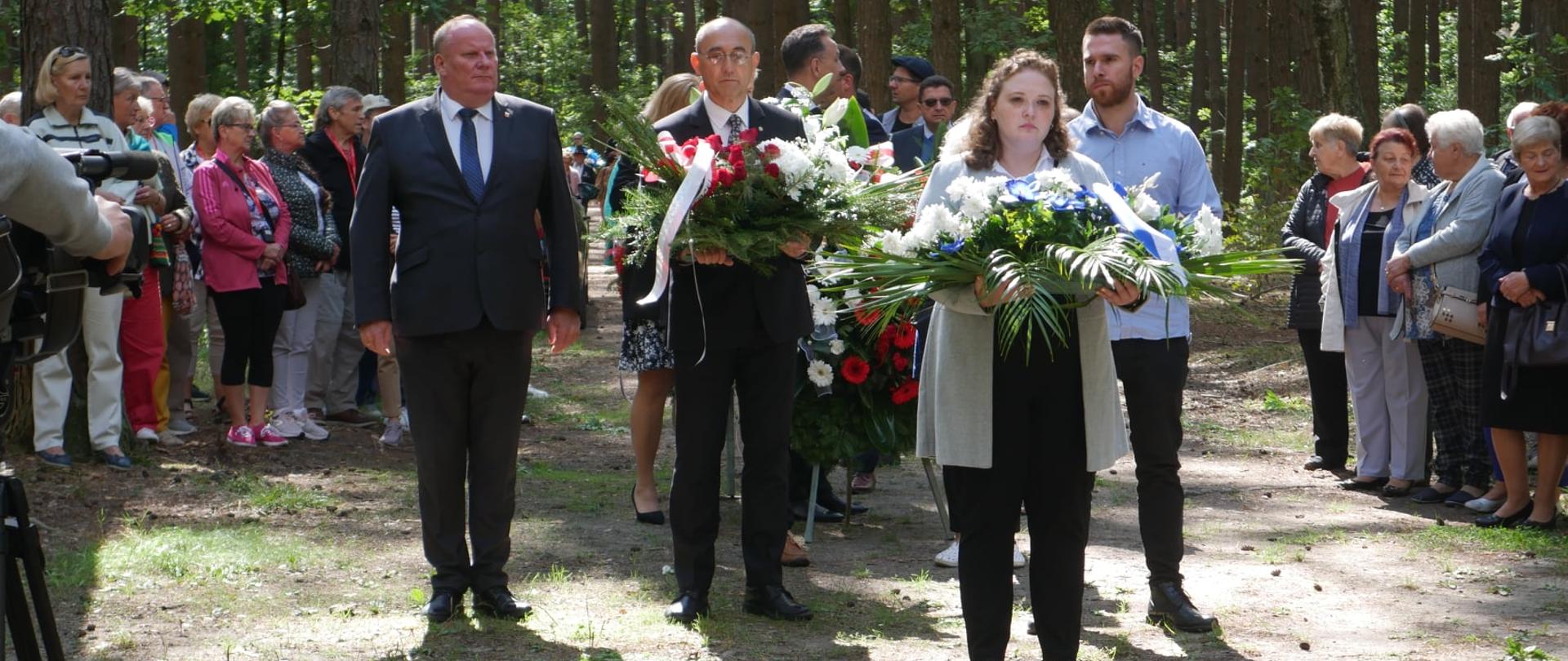 Rocznicowe obchody w lesie łopuchowskim - złożenie kwiatów przed pomnikiem
