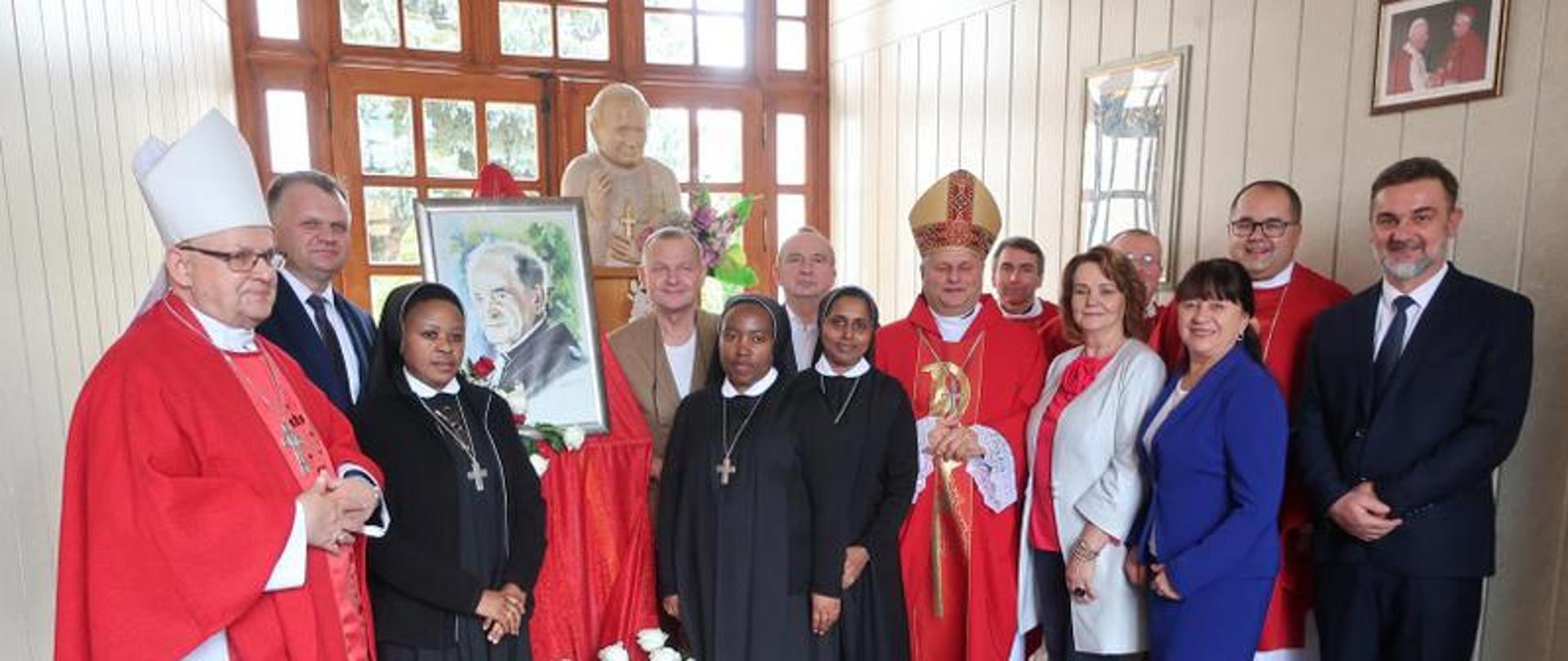 Wspólne zdjęcie uczestników uroczystości przy portrecie ojca Ildebrando Gregoriego