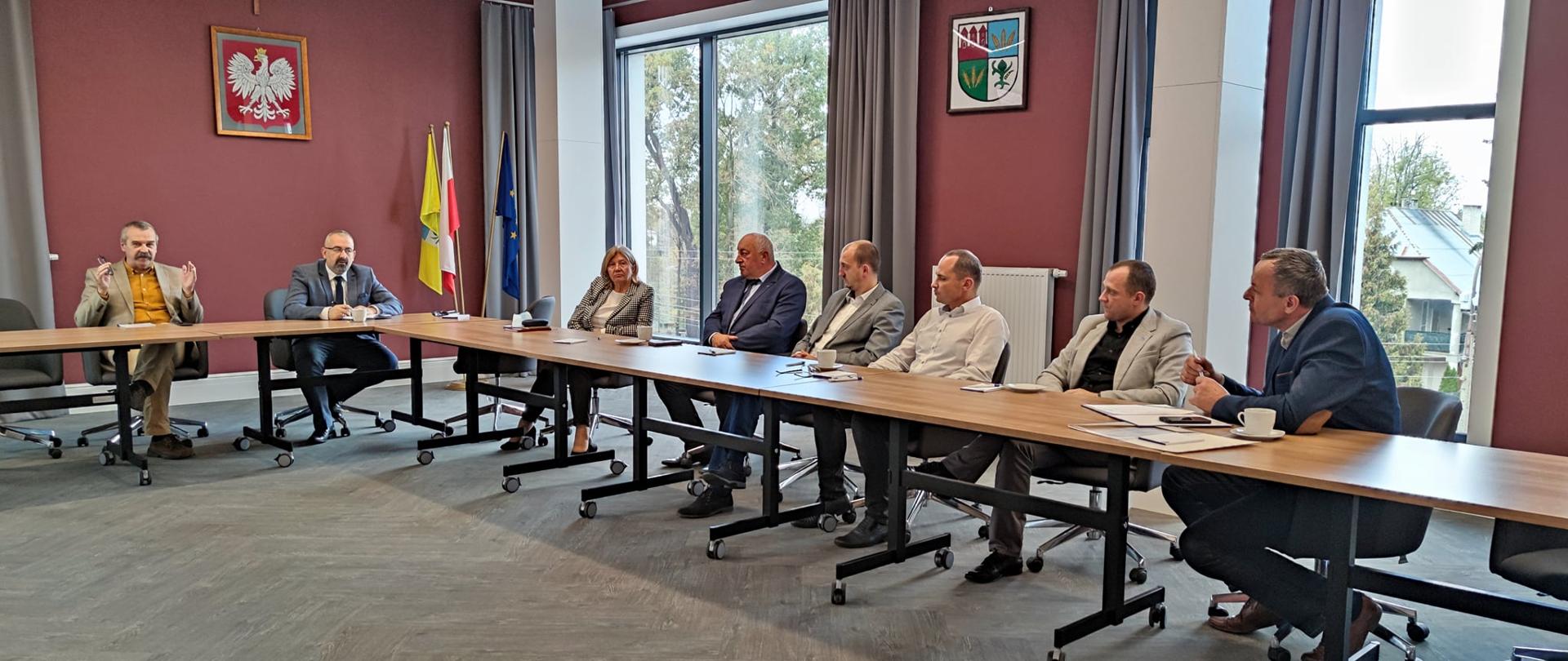 Wspólne zdjęcie samorządowców siedzących przy stole w sali konferencyjnej starostwa