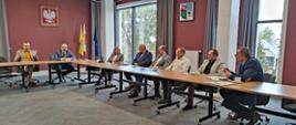 Wspólne zdjęcie samorządowców siedzących przy stole w sali konferencyjnej starostwa