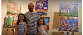 Uczestniczki konkursu pozują przy pracach plastycznych