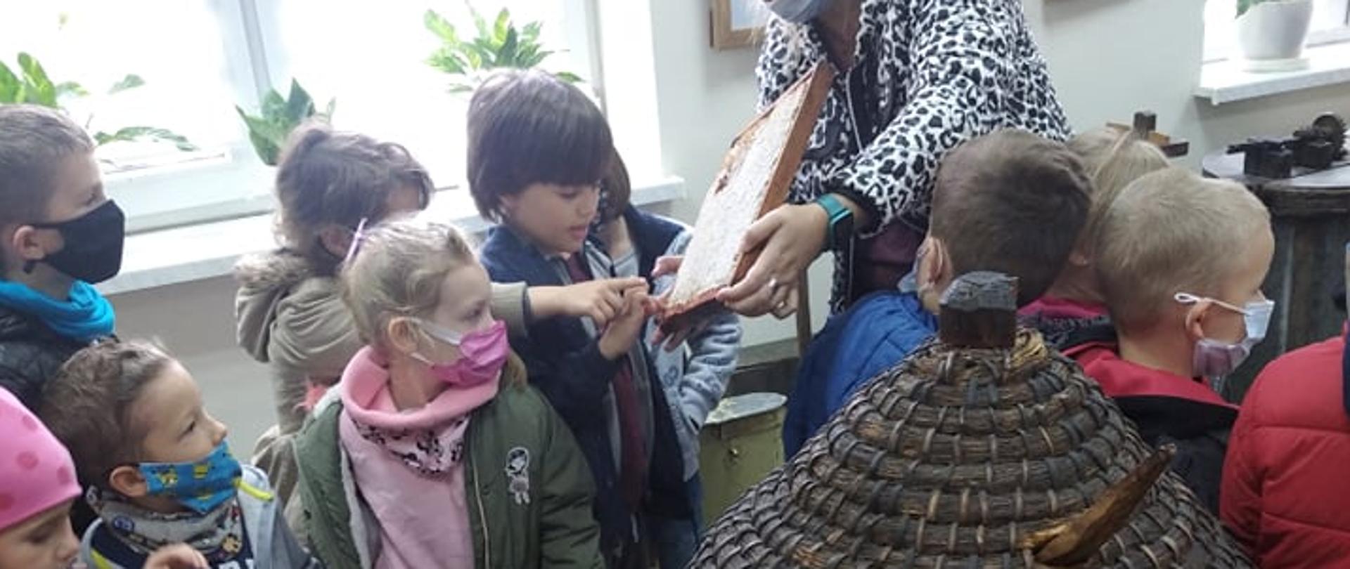 Kobieta pokazuje drewnianą deskę dzieciom