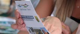 Odwiedzający stoisko przeglądają ulotkę promującą partnerstwo polsko - niemieckie