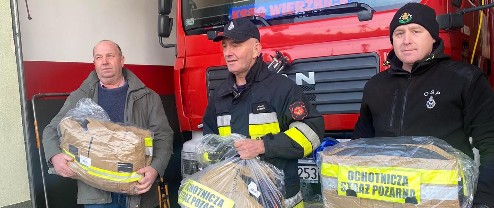 ludzie podczas czynności przekazania sprzętu dla ochotniczej straży pożarnej