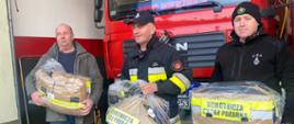 ludzie podczas czynności przekazania sprzętu dla ochotniczej straży pożarnej