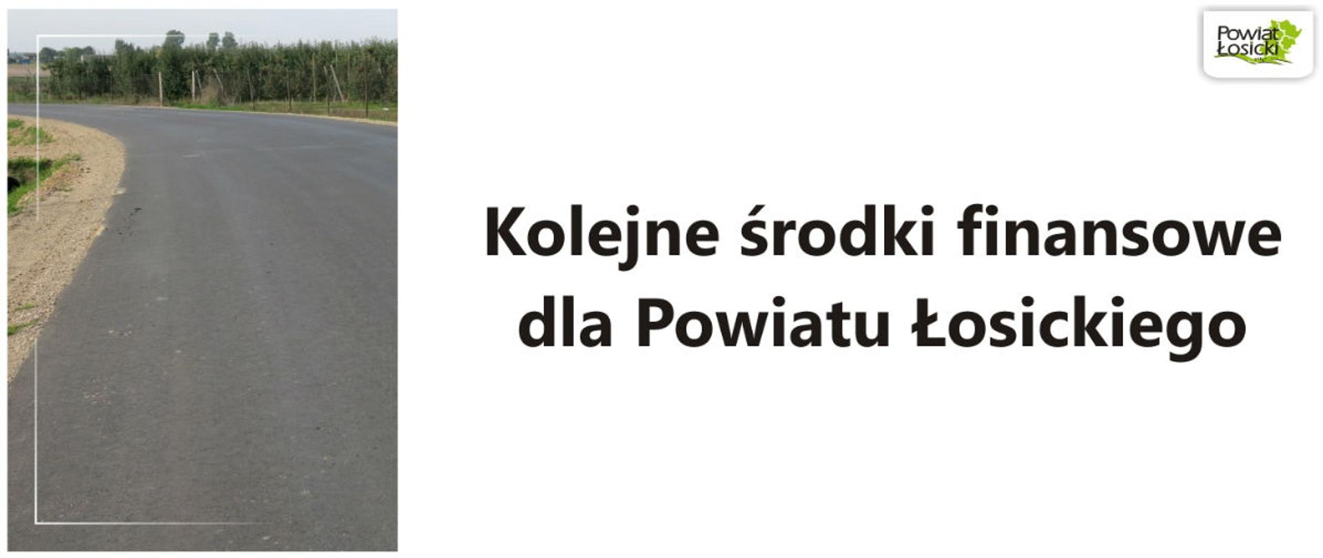 Asfaltowa droga, napis i logo powiatu.