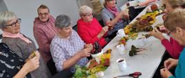Seniorzy wykonujący dekoracje jesienne