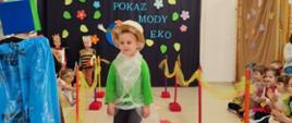 Dzieci ubrane w przygotowane przebrania z recyklingu, idą po "wybiegu" - kolorowym dywanie