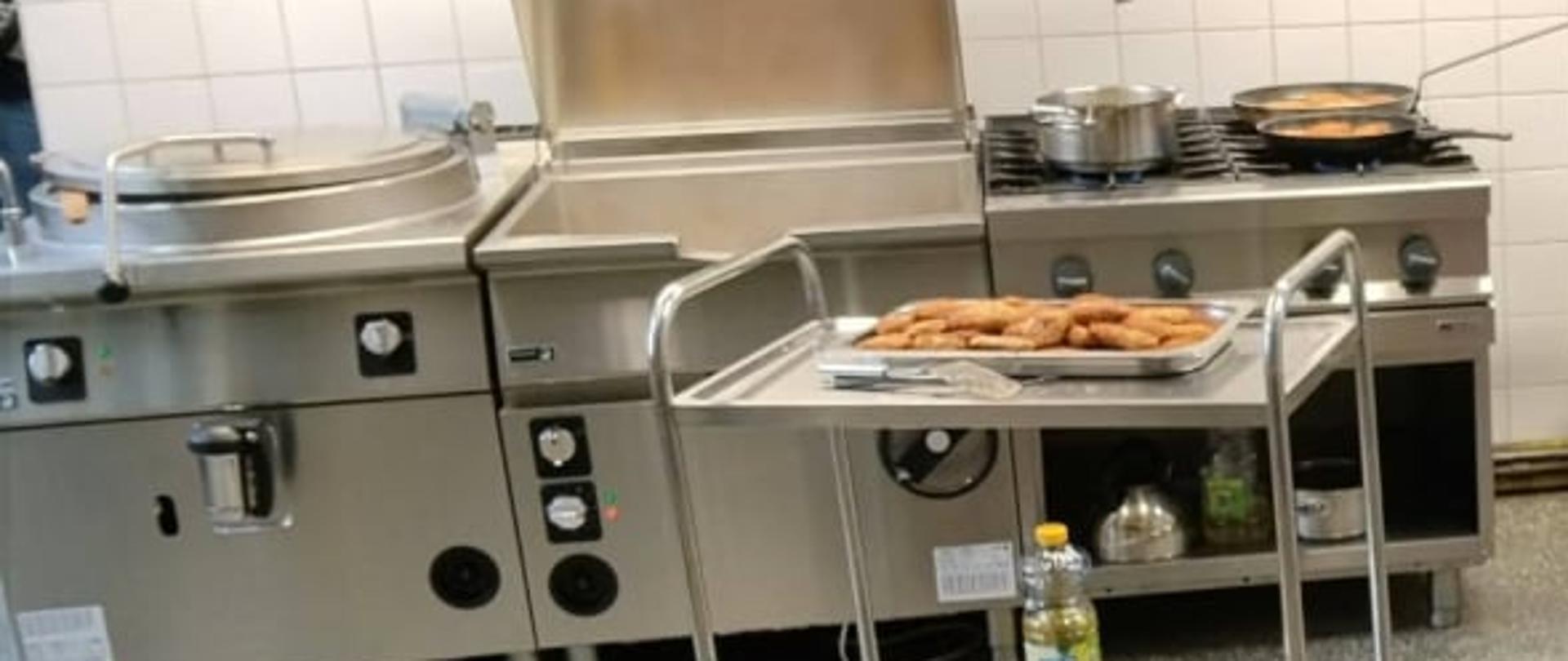 Dzieci obserwują sprzęt w kuchni.
