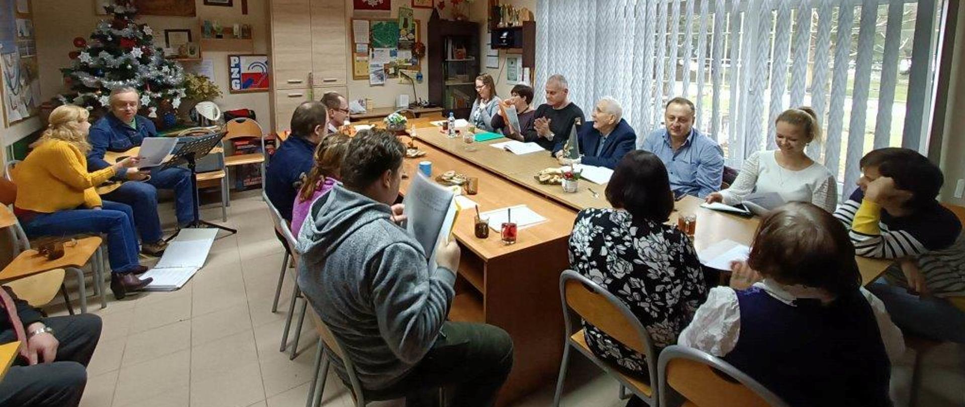 Wspólne kolędowanie - uczestnicy siedzą przy stole