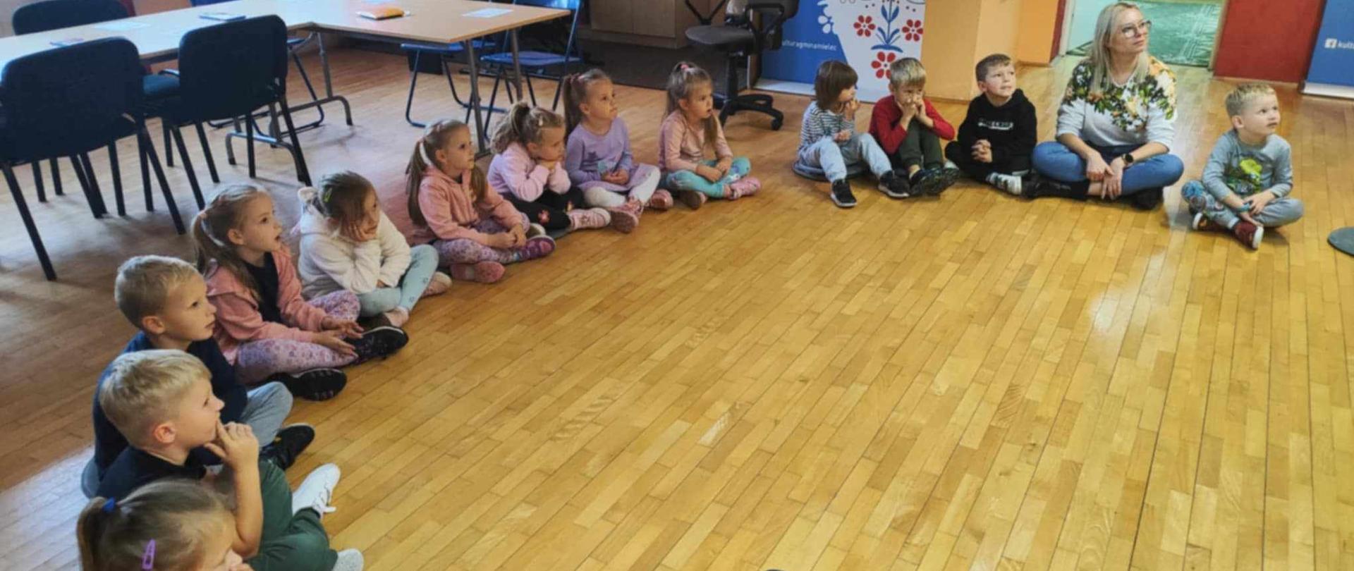 Dzieci siedzące w kole.