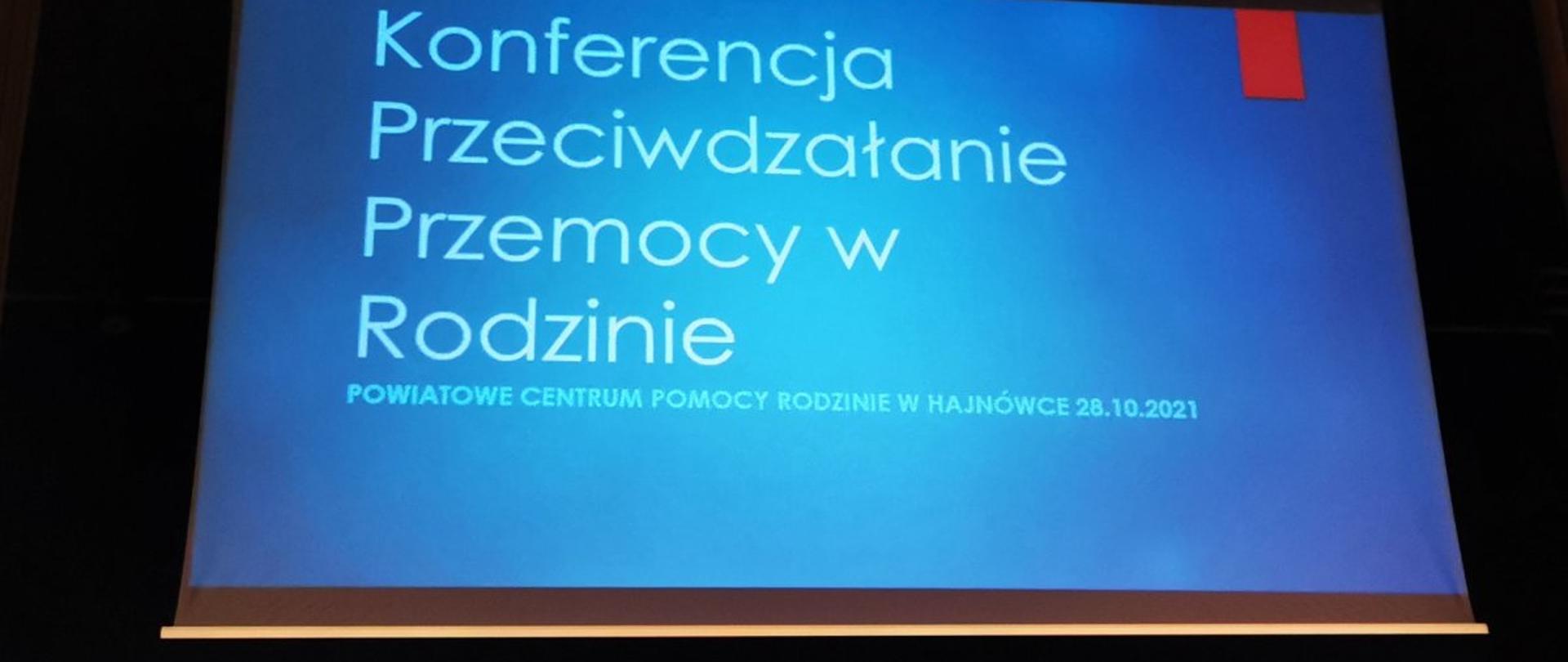 Widok z rzutnika ekranu: slajd wprowadzający do prezentacji. Na niebieskim tle napis "Konferencja przeciwdziałanie przemocy w rodzinie, Powiatowe Centrum Pomocy Rodzinie 28.10.2021"