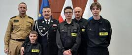 Zdjęcie przedstawia naszych reprezentantów pozujących do zdjęć z opiekunem i członkami komisji