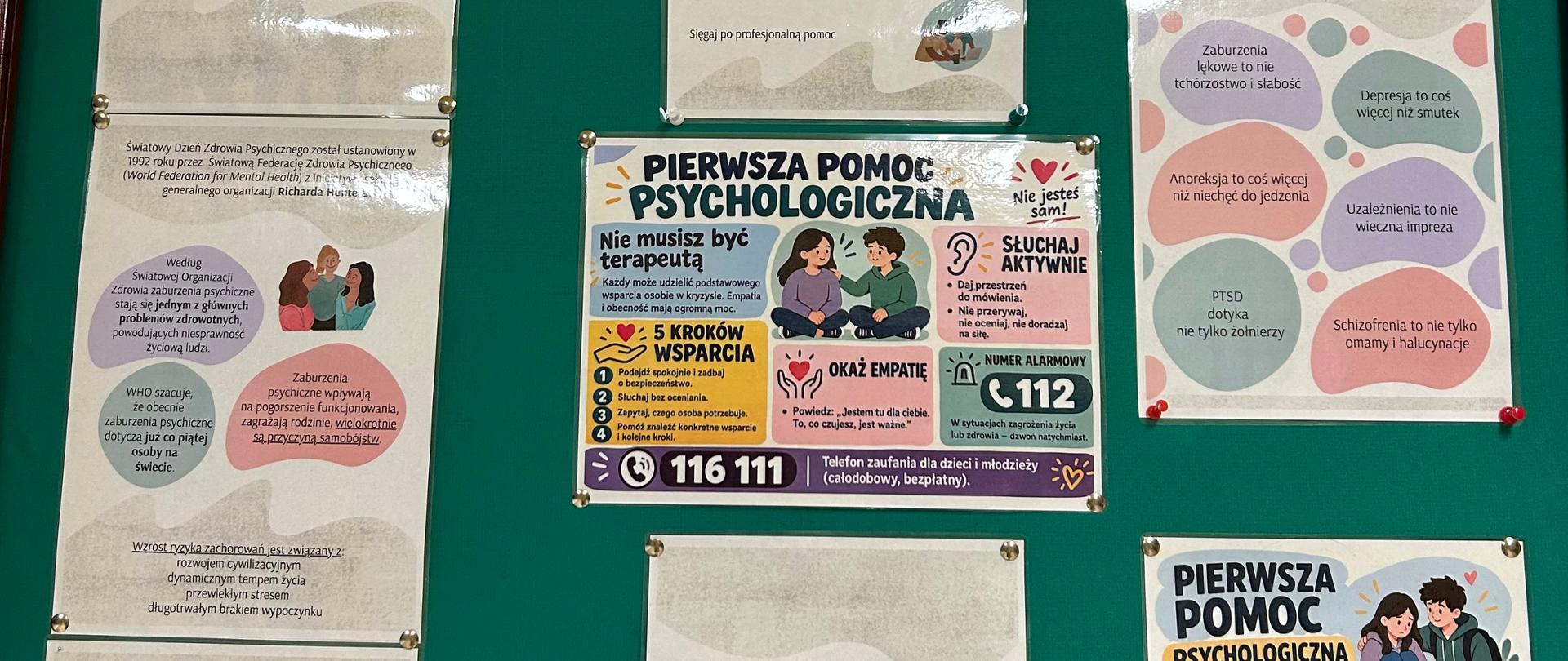 Zielona tablica korkowa z ośmioma plakatami w pastelowych kolorach (fiolet, róż, turkus, żółć), poświęconymi zdrowiu psychicznemu. Po lewej, jeden pod drugim, trzy plakaty: „10 października – Światowy Dzień Zdrowia Psychicznego” z ilustracją przytulającej się grupy osób; plakat z historią święta (ustanowione w 1992 roku przez Światową Federację Zdrowia Psychicznego) i danymi WHO, według których zaburzenia psychiczne dotyczą co piątej osoby na świecie; oraz plakat o tym, że o zdrowie psychiczne trzeba dbać tak jak o fizyczne, i że nie należy bać się szukać pomocy. Pośrodku u góry plakat „Jak dbać o swoje zdrowie psychiczne?” z ilustracjami i wskazówkami, m.in. dbaj o relacje, ciało i aktywność fizyczną, odmawiaj bez tłumaczenia się, kontaktuj się z naturą, sięgaj po profesjonalną pomoc. Pod nim kolorowa infografika „Pierwsza pomoc psychologiczna” z pięcioma krokami wsparcia, wskazówkami o aktywnym słuchaniu i okazywaniu empatii, numerem alarmowym 112 oraz telefonem zaufania dla dzieci i młodzieży 116 111. Na dole w środku plakat z hasłem „Nie wstydź się prosić o pomoc” i ilustracją przytulającej się matki z dzieckiem. Po prawej u góry plakat „Zaburzenia psychiczne to nie »wymysły«!”, obalający mity o zaburzeniach lękowych, depresji, anoreksji, uzależnieniach, PTSD i schizofrenii. Po prawej na dole druga infografika „Pierwsza pomoc psychologiczna: co możesz zrobić, gdy ktoś ma trudny moment?” z krokami: zauważ, podejdź, słuchaj, zapytaj, włącz dorosłego, oraz przypomnieniem o numerze 112.