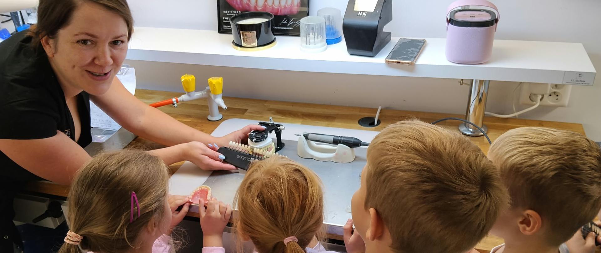 Przedszkolaki z zaciekawieniem oglądają specjalistyczne maszyny i modele szczęki
