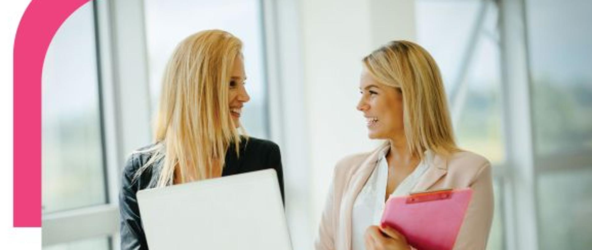 Plakat przedstawia dwie młode kobiety, które rozmawiają ze sobą. Jedna z kobiet trzyma w rękach laptop. Obie są blondynkami i uśmiechają się do siebie. Na plakacie dominują kolory białe i różowe 