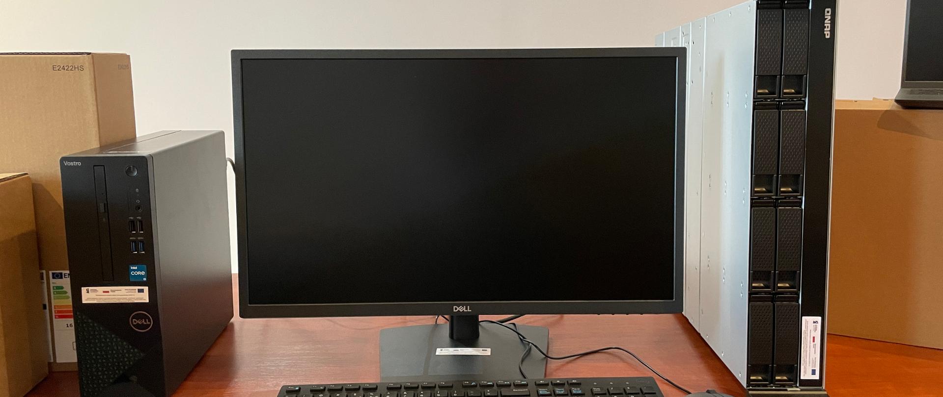 Komputer stacjonarny wraz z monitorem zakupiony w ramach projektu Cyfrowa Gmina, obok serwer plików Qnap.