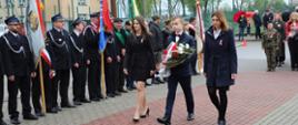 Delegacja dyrektor Barbara Durej, wicedyrektor Alicja Siebierańska i uczeń składają wiązankę na miejscu pamięci