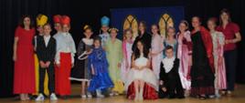 grupa teatralna składająca się z chłopców i dziewczynek ubranych w piękne, stroje 